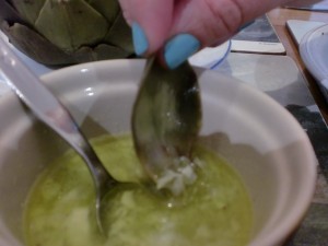 Dip the Artichoke leaf in the sauce then eat the tender part, discarding the tough outer part.